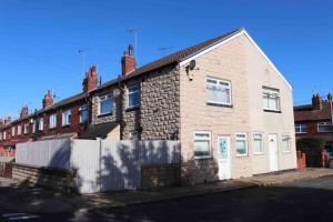 a brick house on the side of a street at Cheerful 2 bedroom residential home - Free parking in Leeds