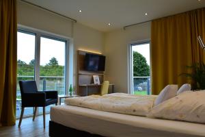 a bedroom with a bed and a desk and a television at Motel Lohwasser in Lichtenau