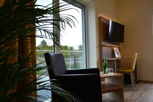 uma sala de espera com uma cadeira e uma planta em Motel Lohwasser em Lichtenau
