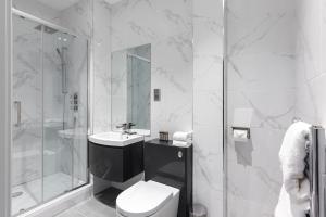 a bathroom with a toilet and a sink and a shower at Aptel East in London