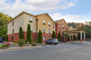 a building with a car parked in a parking lot at Comfort Inn & Suites in Canton