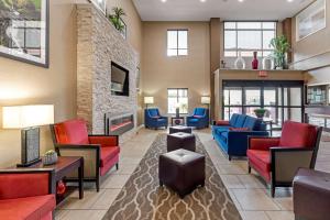 vestíbulo con muebles rojos y azules y chimenea en Comfort Inn & Suites, en Canton