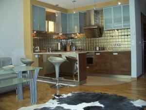 uma cozinha com armários azuis e uma mesa e cadeiras em Apartament Stara Polana i Spa em Zakopane