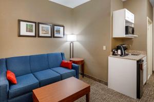 un soggiorno con un divano blu e un tavolo di comfort & inn Suites a Canton