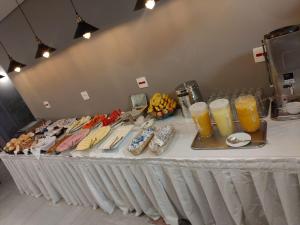 サンパウロにあるUniclass Hotel Pinheirosの食べ物とオレンジジュースのグラスが詰まったテーブル