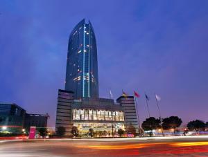 Un edificio alto con un sacco di luci sopra di Crowne Plaza Wuxi City Center a Wuxi