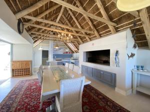 a dining room with a long table and a tv at Induku in Paternoster