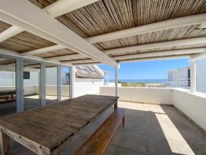 a wooden table on the balcony of a house at Induku in Paternoster