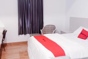 Un dormitorio con una cama con una manta roja. en RedDoorz near Exit Tol Kotabaru ITERA Lampung, en Kedaton