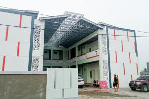un edificio con coches estacionados frente a él en RedDoorz near Exit Tol Kotabaru ITERA Lampung, en Kedaton