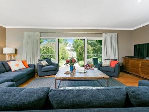 uma sala de estar com sofás azuis e uma mesa de centro em Sinden Park em Exeter