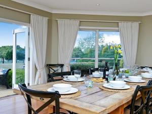 a dining room table with chairs and a large window at Sinden Park in Exeter