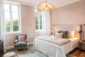 a bedroom with a bed and a blue chair at Boutique Hotel SOCLO in Toulouse