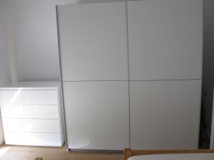 un armario blanco junto a una nevera en una habitación en FeWoMeißner en Wittingen