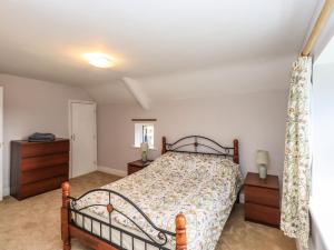 a bedroom with a bed and a dresser and a window at The Duck House in Carlisle