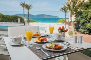 a table with food and drinks and a view of the beach at Iberostar Waves Cala Millor - Adults Only in Cala Millor