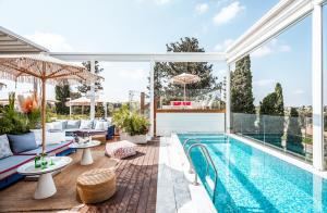 an indoor swimming pool with a patio furniture and a swimming poolvisor at Lear Sense Hotel in Gedera