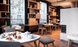 un restaurante con mesas y sillas con comida. en Hotel Max, en París