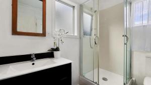 a bathroom with a glass shower and a sink at ULTIMATE CONVENIENCE, WALK-TO-TOWN TOWNHOUSE in Queenstown