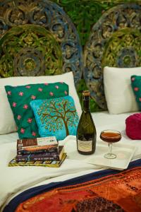 - une bouteille de vin et un verre sur le lit dans l'établissement Bhim Kothi, à Jaisalmer