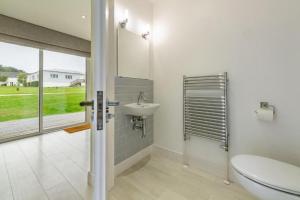 une salle de bain avec toilettes, lavabo et fenêtre dans l'établissement West Bay Cottages Yarmouth Isle of Wight, à Yarmouth 111 autres photos