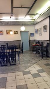 a dining room with tables and chairs and a blue door at SEO Motel Alavieska in Alavieska