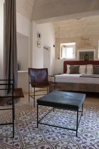 a bedroom with a bed and two chairs and a table at Borgo dei Lecci Puglia in Selva di Fasano