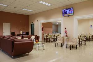 Hotel Cuesta de Miranda II في فيلا يونون: غرفة انتظار مع كنب وطاولات وكراسي