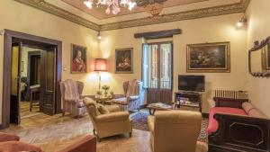a living room with a couch and chairs and a tv at Villa Buon Viaggio 16, Emma Villas in Orvieto