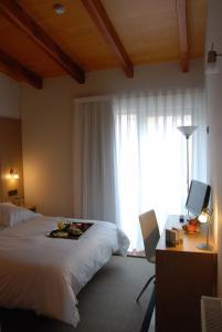 a bedroom with a bed and a desk and a window at Hotel de Naturaleza AV - Adults Only in Ameixenda