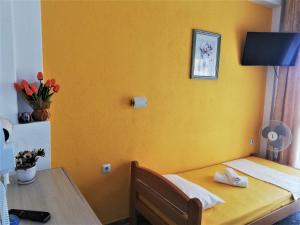 アスプロヴァルタにあるKLetnikoviの黄色の壁の客室で、テーブルとベッドが備わります。