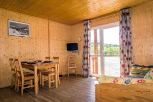 a room with a table and a dining room with a window at les balcons du grand puy in Seyne