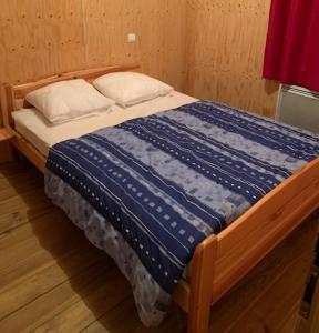 1 cama con edredón azul y 2 almohadas en les balcons du grand puy en Seyne