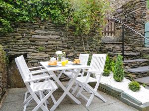 una mesa blanca y 2 sillas en el patio en Snowdrop Cottage, en Windermere