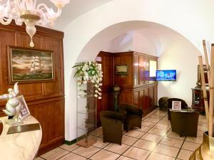 un soggiorno con lampadario pendente, tavolo e sedie di Hotel Regina Margherita a Roma