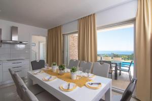 kuchnia i jadalnia z białym stołem i krzesłami w obiekcie Villas Royal I with Private Pool w Novalji
