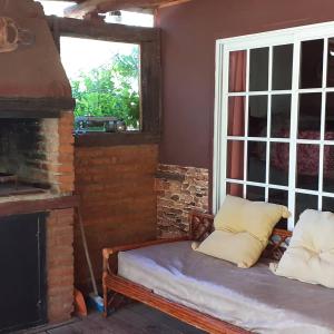 Habitación con cama, chimenea y ventana en Cabañas "La Quimera" en El Durazno