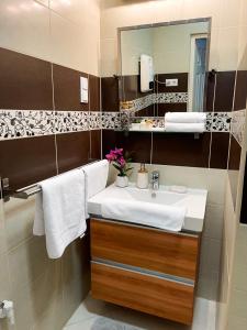 łazienka z umywalką i lustrem w obiekcie Greatforest Rosehill 1 Apartman w Debreczynie