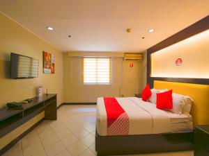 a hotel room with a bed and a desk at OYO 115 Northridge Mansions in Manila