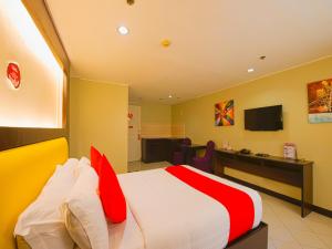 Schlafzimmer mit einem Bett mit roten und weißen Kissen in der Unterkunft OYO 115 Northridge Mansions in Manila