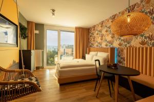 ミュンヘンにあるRioca Munich Posto 3のベッドとテーブルが備わるホテルルームです。