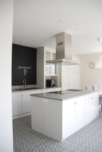 a white kitchen with white cabinets and a sink at Vakantiewoning Kastijd Kortessem in Kortessem