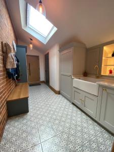 a kitchen with white cabinets and a skylight at New Converted Barn in Hereford