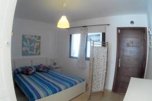sypialnia z łóżkiem, oknem i drzwiami w obiekcie CasaMandy CotilloMar w mieście Cotillo