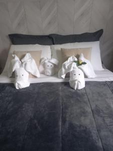 a group of white stuffed animals on a bed at Kitnet Recanto de Campos-Pertinho do Centro in Campos do Jordão