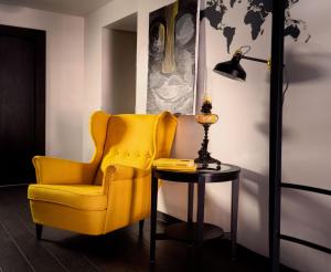 una silla amarilla y una mesa con lámpara en Hotel Shato Gesson en Praga