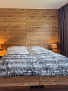a bedroom with a bed with a wooden wall at Chalet Lenzi in Sankt Anton am Arlberg