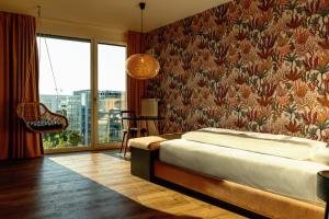 een slaapkamer met een bed en een groot raam bij Rioca Munich Posto 3 in München