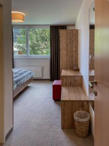 Schlafzimmer mit einem Bett, einem Tisch und einem Fenster in der Unterkunft Chalet Lenzi in Sankt Anton am Arlberg