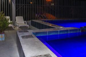 a swimming pool with a bench and a chair next to it at Soga Hostal in Santa Marianita